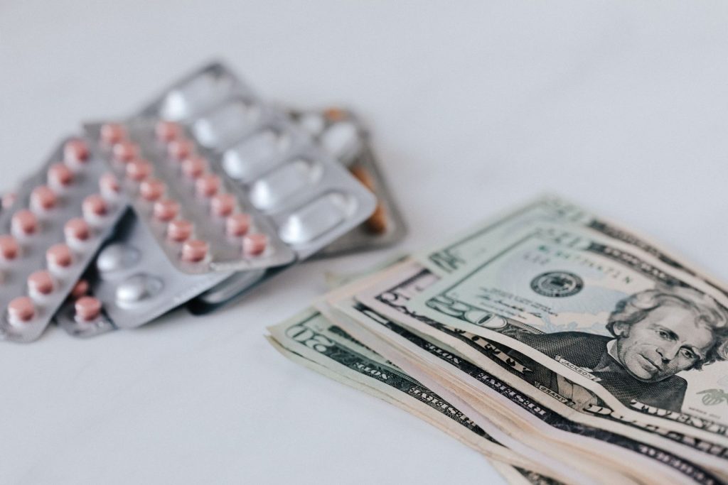 Medication beside U.S. dollar bills illustrating healthcare costs