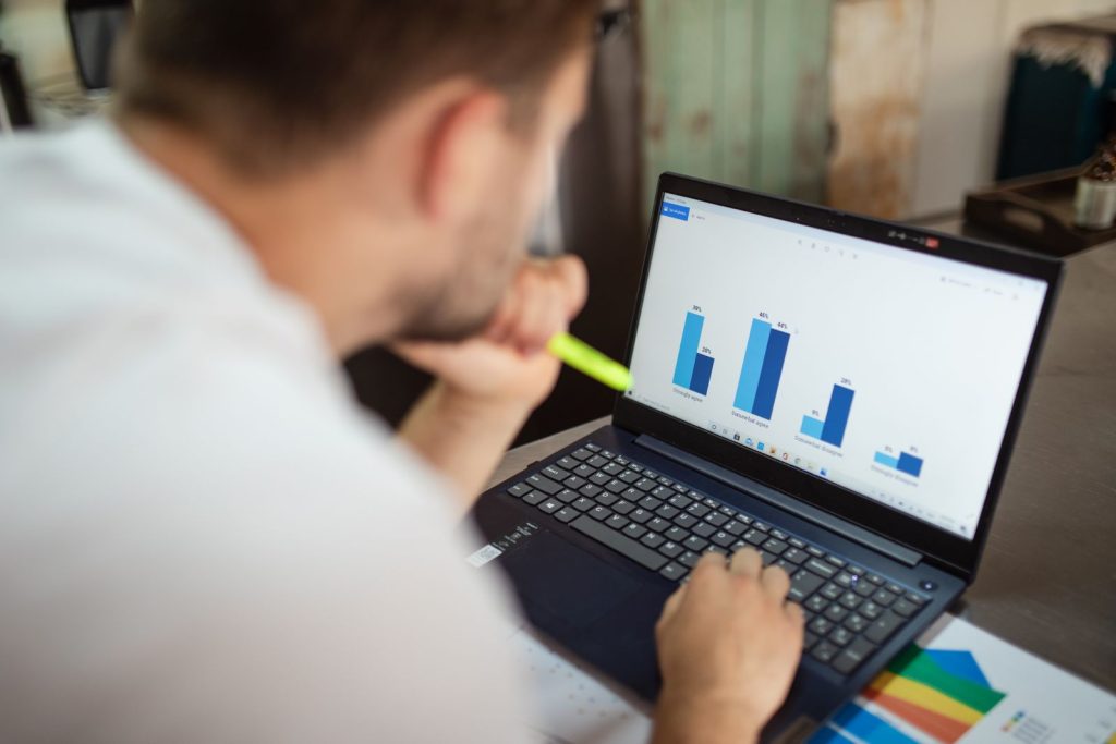 Person reviewing bar chart data on a laptop